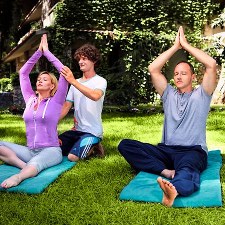 Marti Myra Hotel Tekirova Luaran gambar A yoga teacher assists students with their practice.